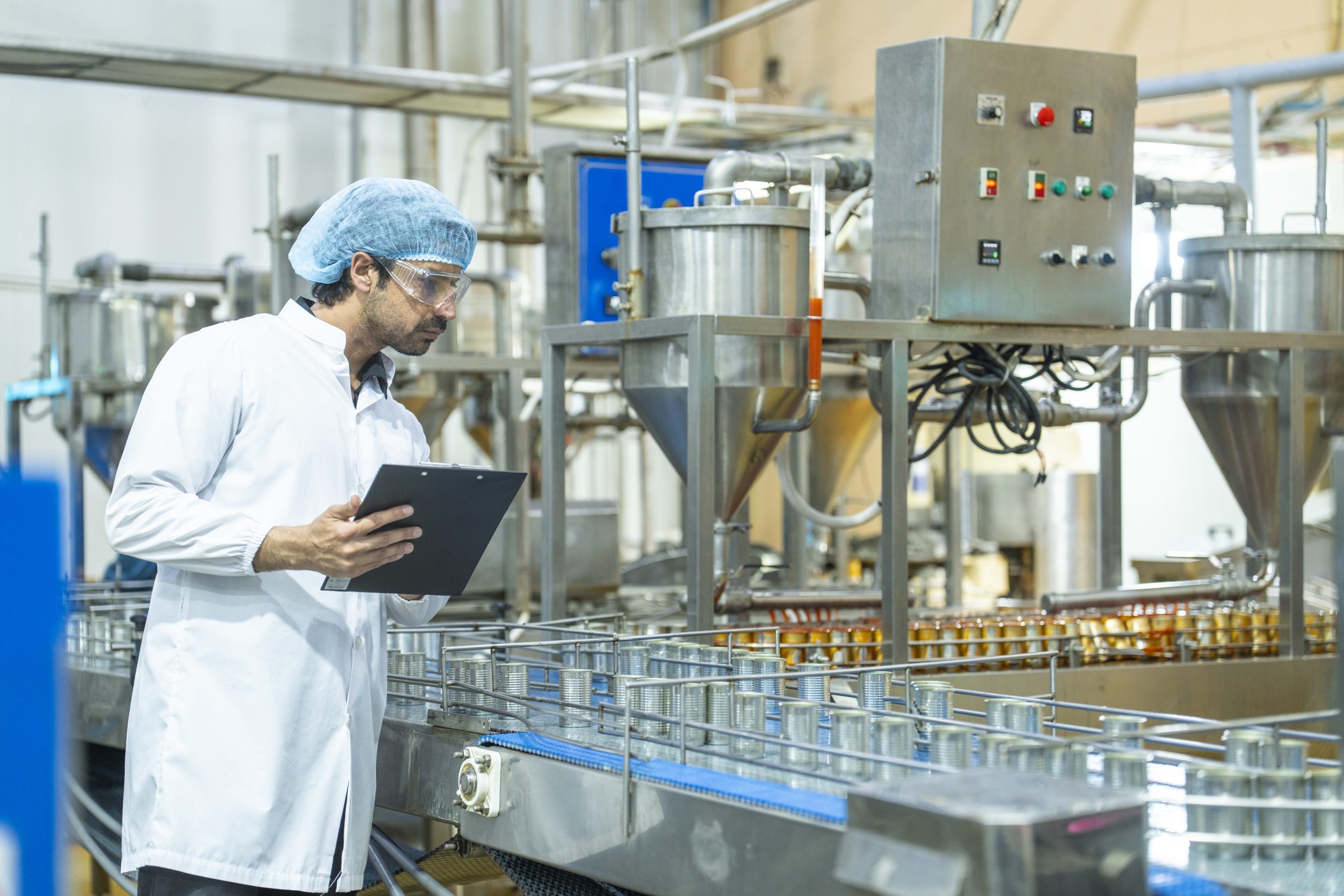 Factory worker inspecting production line equipment.